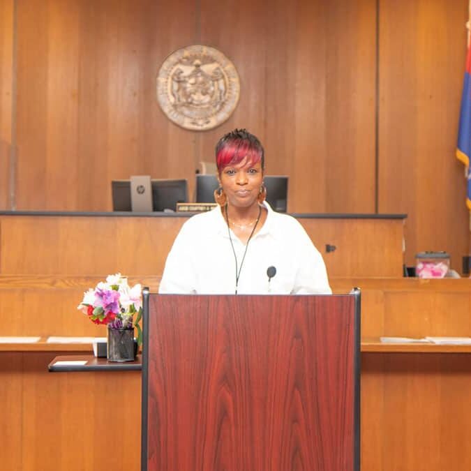 A Kansas City Wellness Court graduate stands behind a podium