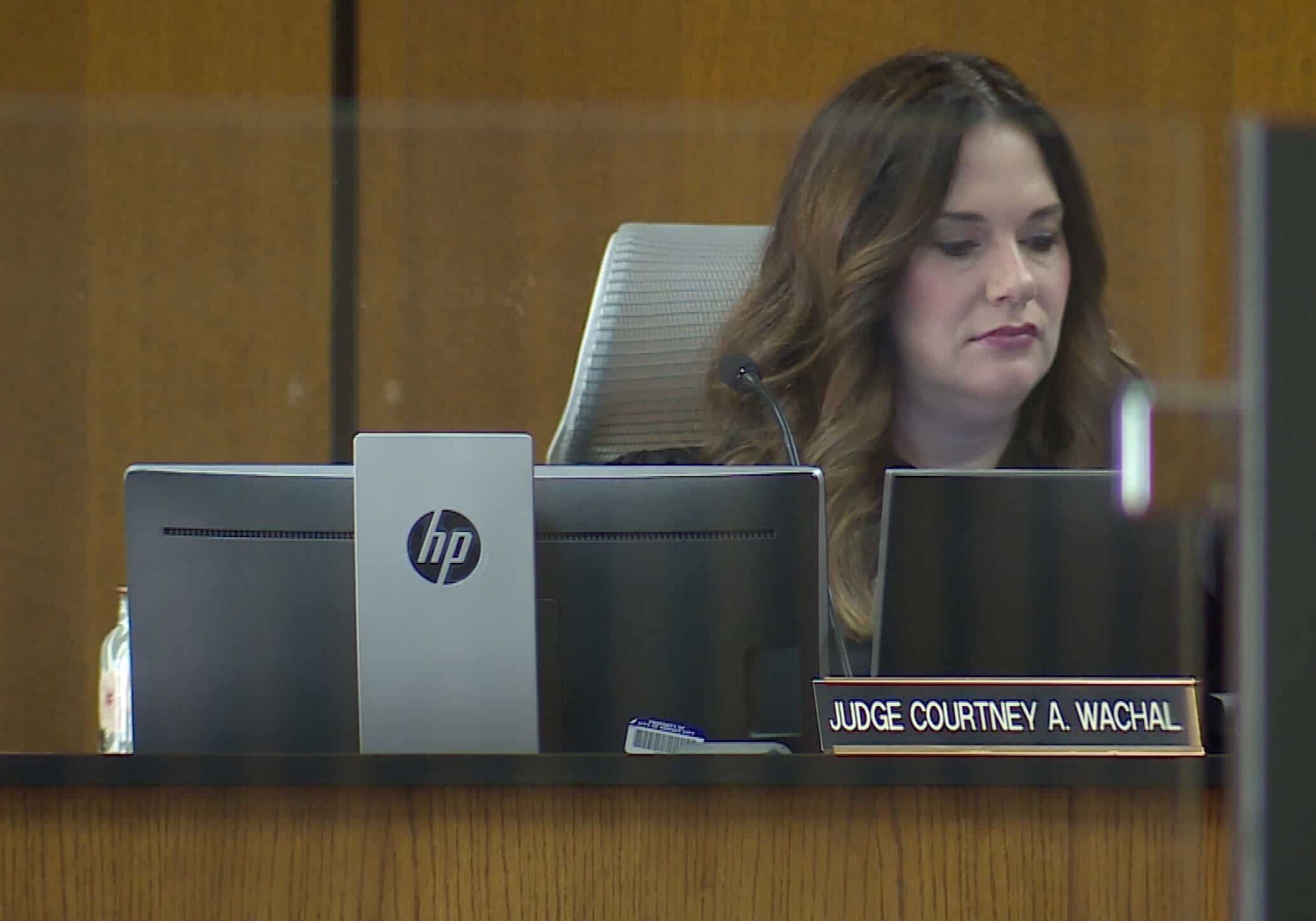 Judge Courtney Wachal sitting at a desk with her nameplate while looking at a computer